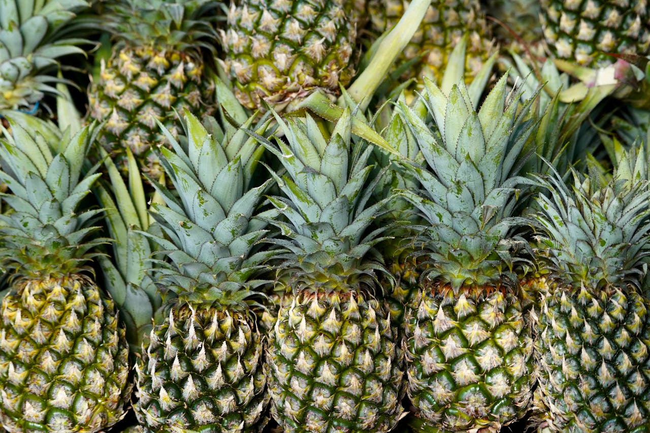 Close-up view of fresh pineapples in a stack, showcasing their unique texture and vibrant colors.